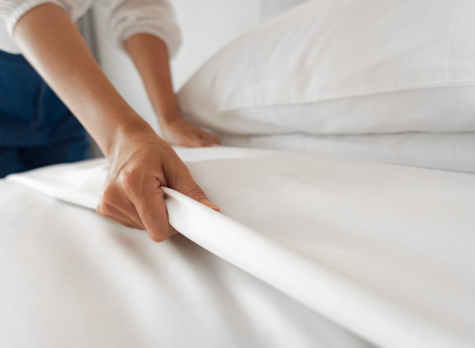 Woman adjusting sheets on a bed